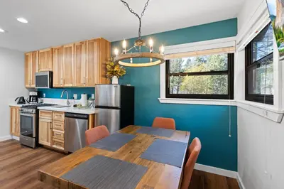 a kitchen with a table and a dining room at Sandy Cove on the North Shore -Lakeside Cottage with Pier Beach, and HOA Amenities in Tahoe Vista
