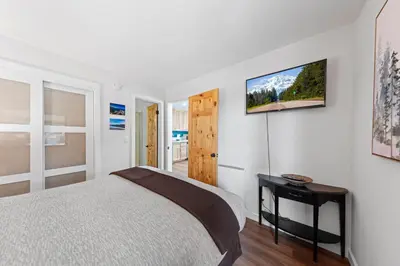 a bedroom with a bed and a tv on the wall at Sandy Cove on the North Shore -Lakeside Cottage with Pier Beach, and HOA Amenities in Tahoe Vista