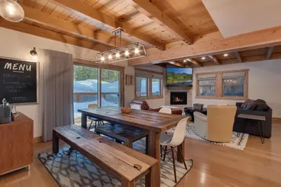 a dining room with a table and a living room at Olympic Valley Hideaway - Newly Remodeled Cabin with Private Hot Tub in Olympic Valley
