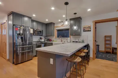 a kitchen with stainless steel appliances and wooden floors at Olympic Valley Hideaway - Newly Remodeled Cabin with Private Hot Tub in Olympic Valley