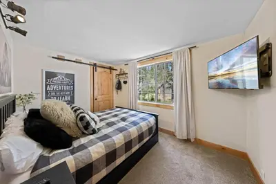 a bedroom with a bed and a tv on the wall at Rustling Grove in Tahoe City - Pet-Friendly, Walking Distance to Downtown and Lake - Private Hot Tub in Tahoe City