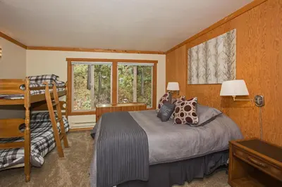 a bedroom with a bed and a ladder and a window at Palisades Tahoe Ski Condo by Tahoe Getaways - Remodeled 2 BR, Walking Distance to Lifts & Village in Olympic Valley