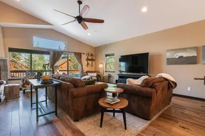 a living room with two couches and a flat screen tv at Pinecrest at Winter Creek- Cozy Cabin w Hot Tub, Walk To Downtown Truckee in Truckee