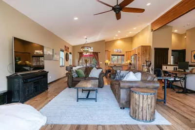 a living room with leather furniture and a ceiling fan at Pinecrest at Winter Creek- Cozy Cabin w Hot Tub, Walk To Downtown Truckee in Truckee