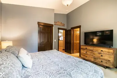a bedroom with a large bed and a flat screen tv at Pinecrest at Winter Creek- Cozy Cabin w Hot Tub, Walk To Downtown Truckee in Truckee