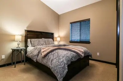 a bedroom with a large bed and a window at Pinecrest at Winter Creek- Cozy Cabin w Hot Tub, Walk To Downtown Truckee in Truckee