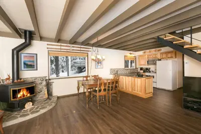 a kitchen and dining room with a fireplace and a dining table at Pineland Chalet in Tahoe City - Classic Cabin Wood Fireplace Dog Friendly in Tahoe City