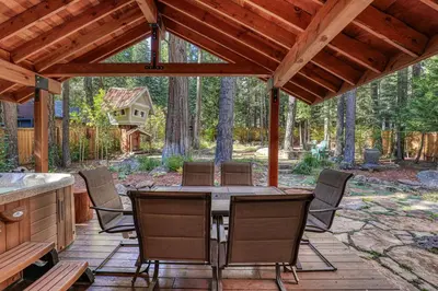 a wooden patio with a table and chairs at Secret Garden Lodge - 4BR Walking Distance to the Lake, Hot Tub, Close to Ski Resorts! in Carnelian Bay