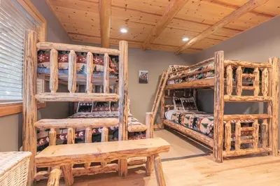 a log cabin bedroom with two bunk beds at Secret Garden Lodge - 4BR Walking Distance to the Lake, Hot Tub, Close to Ski Resorts! in Carnelian Bay
