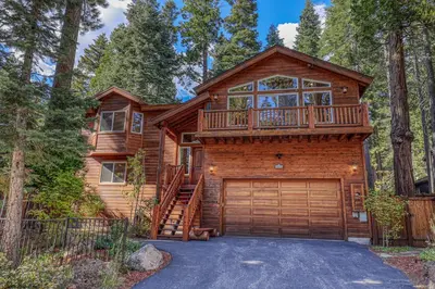 a log home with a large deck and a garage at Secret Garden Lodge - 4BR Walking Distance to the Lake, Hot Tub, Close to Ski Resorts! in Carnelian Bay
