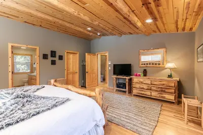 a bedroom with a bed and a flat screen tv at Secret Garden Lodge - 4BR Walking Distance to the Lake, Hot Tub, Close to Ski Resorts! in Carnelian Bay