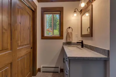 a bathroom with a sink and a wooden door at Silver Tip at Tahoe Park w HOA amenities - 3BR Pet Friendly, Hot Tub, Tahoe City in Tahoe City