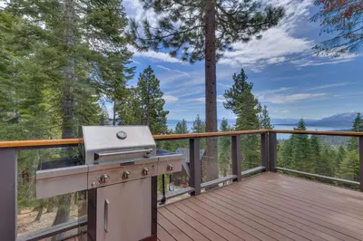 a grill on a deck with a view of trees at Tahoe Point of View - Amazing Lake Views at this 4BR w Hot Tub, Sauna, Near Skiing in Tahoe City