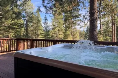 a hot tub sitting on a deck with water at Starlight Retreat at Gray's Crossing in Truckee