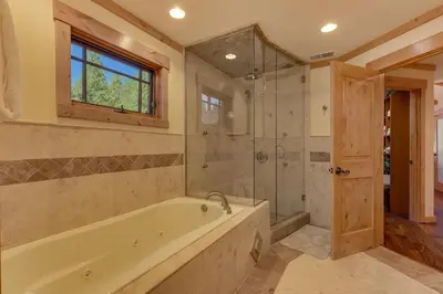 a bathroom with a tub and a glass shower at Starlight Retreat at Gray's Crossing in Truckee