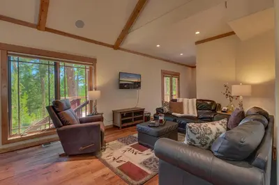 a living room with leather furniture and a large window at Starlight Retreat at Gray's Crossing in Truckee