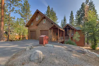 a house in the woods with a driveway at Tahoe Rim Retreat - Spacious 4BR with Pool Table and Private Hot Tub - Pet Friendly! in Kings Beach