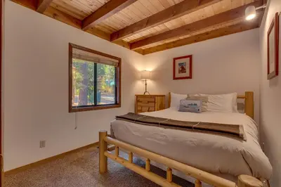 a bedroom with a bed and a window at Tahoe Woods by Tahoe Getaways - Pet Friendly Tahoe Park Cabin w Hot Tub, Fireplace, Near Skiing! in Tahoe City