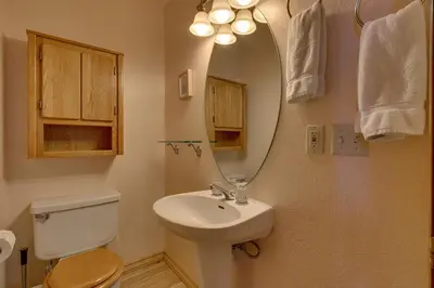a bathroom with a toilet and a sink with a mirror at Tahoe Woods by Tahoe Getaways - Pet Friendly Tahoe Park Cabin w Hot Tub, Fireplace, Near Skiing! in Tahoe City