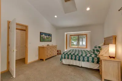 a bedroom with a bed and a dresser and a window at Tahoma Charm on West Shore - Beautiful Open Concept 3 BR w Private Hot Tub in Tahoma