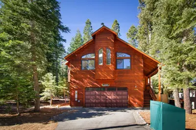 a wooden house with a garage in the woods at Tahoma Charm on West Shore - Beautiful Open Concept 3 BR w Private Hot Tub in Tahoma