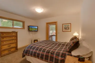 a bedroom with a bed and a dresser at Tahoma Charm on West Shore - Beautiful Open Concept 3 BR w Private Hot Tub in Tahoma
