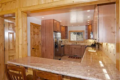 a large kitchen with wooden cabinets and a large island at Valley View at Palisades -4 BR w Mountain Views, Pet-Friendly, and Close to Village in Olympic Valley
