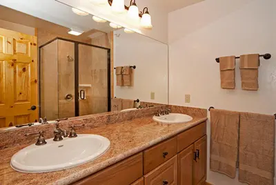 a bathroom with two sinks and a large mirror at Valley View at Palisades -4 BR w Mountain Views, Pet-Friendly, and Close to Village in Olympic Valley