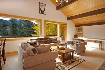 a living room filled with furniture and a large window at Valley View at Palisades -4 BR w Mountain Views, Pet-Friendly, and Close to Village in Olympic Valley
