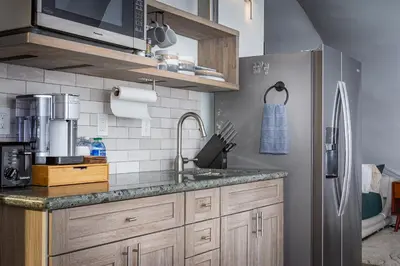 a kitchen with a sink and a refrigerator at Sequoia Studio Suites in Three Rivers