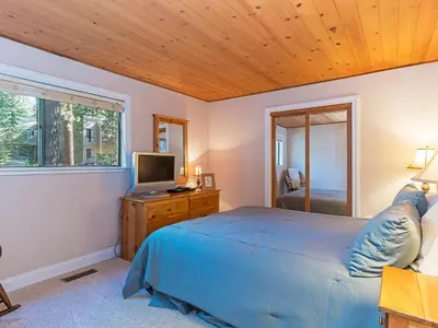 a bedroom with a blue bed and a television at 223 Forest Pines short walk to bike path and the Hyatt Casino in Incline Village