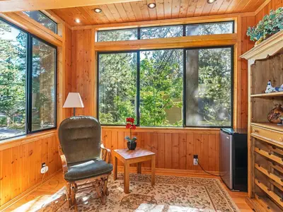 a room with a chair and a table and windows at 223 Forest Pines short walk to bike path and the Hyatt Casino in Incline Village