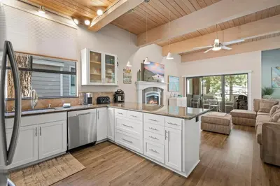 a kitchen with white cabinets and a living room at The perfect Forest Pines getaway in Incline Village