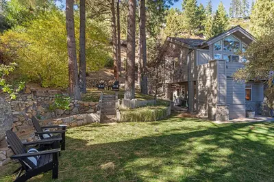 a home in the woods with a stone wall at Fabulous Views Of Lake Tahoe in Crystal Bay