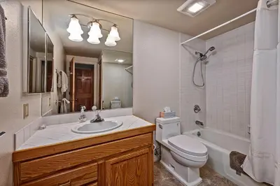a bathroom with a sink and a toilet and a tub at 5 McCloud - Bright and Quaint Living in Incline Village