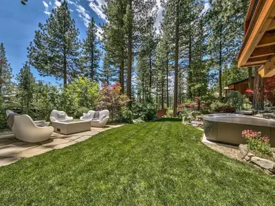 a backyard with a lawn with chairs and a bathtub at A Touch Of Tuscany In a Lake Tahoe Estate in Incline Village