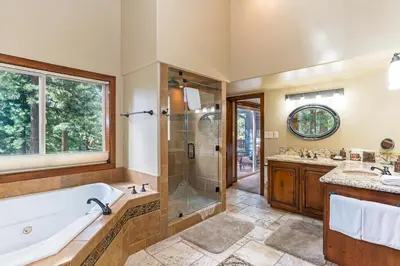 a bathroom with a tub and a shower and a sink at 585 Knotty Pine - Gorgoeous Moutain Home in Incline Village