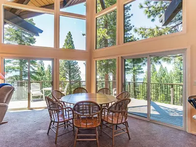 a large room with a table and chairs and windows at Enjoy the brilliant views of Lake Tahoe from this mountainside Cabin in Incline Village