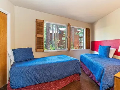 two beds in a room with two windows at Enjoy the brilliant views of Lake Tahoe from this mountainside Cabin in Incline Village