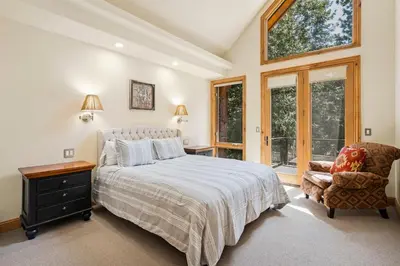 a bedroom with a bed and a chair and a window at Spectacular low elevation home at its finest! in Incline Village