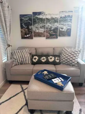 a living room with a couch and some paintings at California Cottage in Tracy