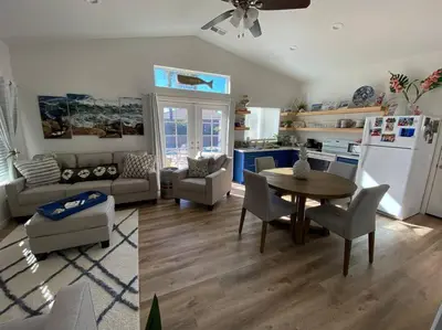 a kitchen and living room with a table and a refrigerator at California Cottage in Tracy