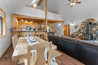 a kitchen and living room with a table and a couch at Tranquil Tahoe A-Frame Walk to Beach in Tahoe Vista