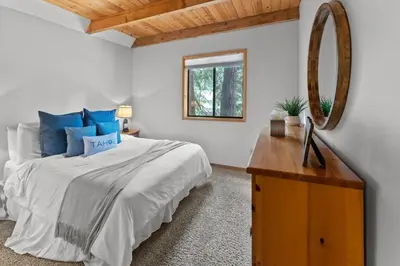 a bedroom with a bed and a mirror and a dresser at Tranquil Tahoe A-Frame Walk to Beach in Tahoe Vista