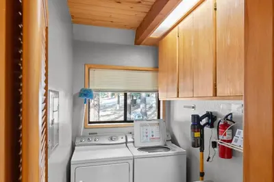 a small kitchen with a washing machine and a window at Tranquil Tahoe A-Frame Walk to Beach in Tahoe Vista
