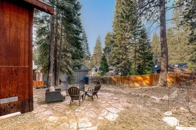 a patio with chairs and a table in a yard at Tranquil Tahoe A-Frame Walk to Beach in Tahoe Vista