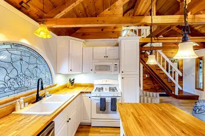 a kitchen with white appliances and wooden ceilings at Casa nel Bosco in Arnold