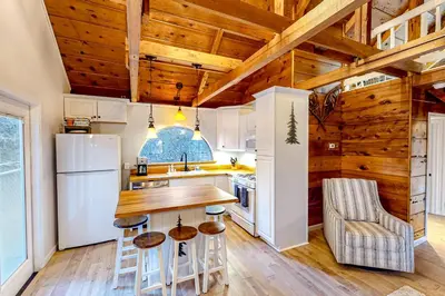 a kitchen with wooden ceilings and a wooden table and chairs at Casa nel Bosco in Arnold