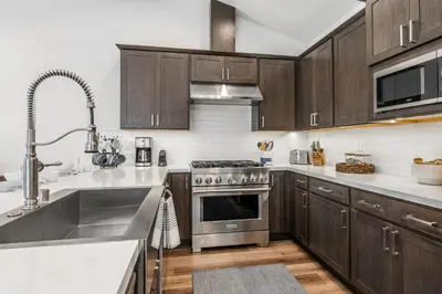 a kitchen with stainless steel appliances and wooden cabinets at Creekhouse 1380 in Mammoth Lakes