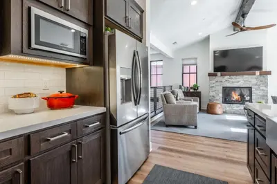 a kitchen with a refrigerator and a living room at Creekhouse 1380 in Mammoth Lakes